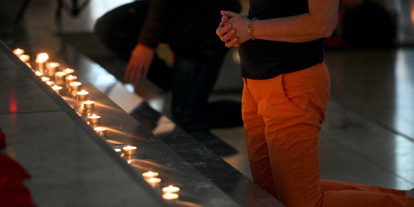 Menschen knien vor einem Kerzenaltar bei der Initiative 'Nightfever' in der Domkirche Sankt Eberhard beim 102. Deutschen Katholikentag am 29. Mai 2022 in Stuttgart.