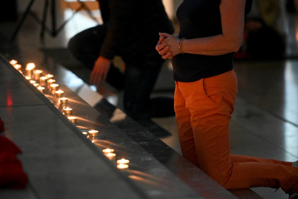 Menschen knien vor einem Kerzenaltar bei der Initiative 'Nightfever' in der Domkirche Sankt Eberhard beim 102. Deutschen Katholikentag am 29. Mai 2022 in Stuttgart.